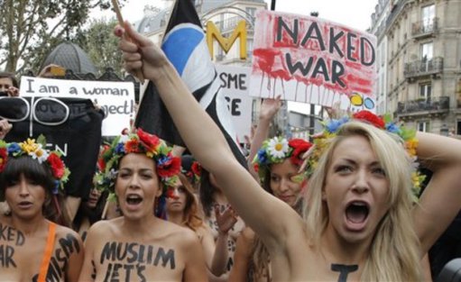 Ukraine's Inna Shevchencko, right, and other activists members of the women's rights group Femen, chants slogans during a topless march in Paris, Tuesday, Sept, 18, 2012. (AP Photo/Francois Mori)